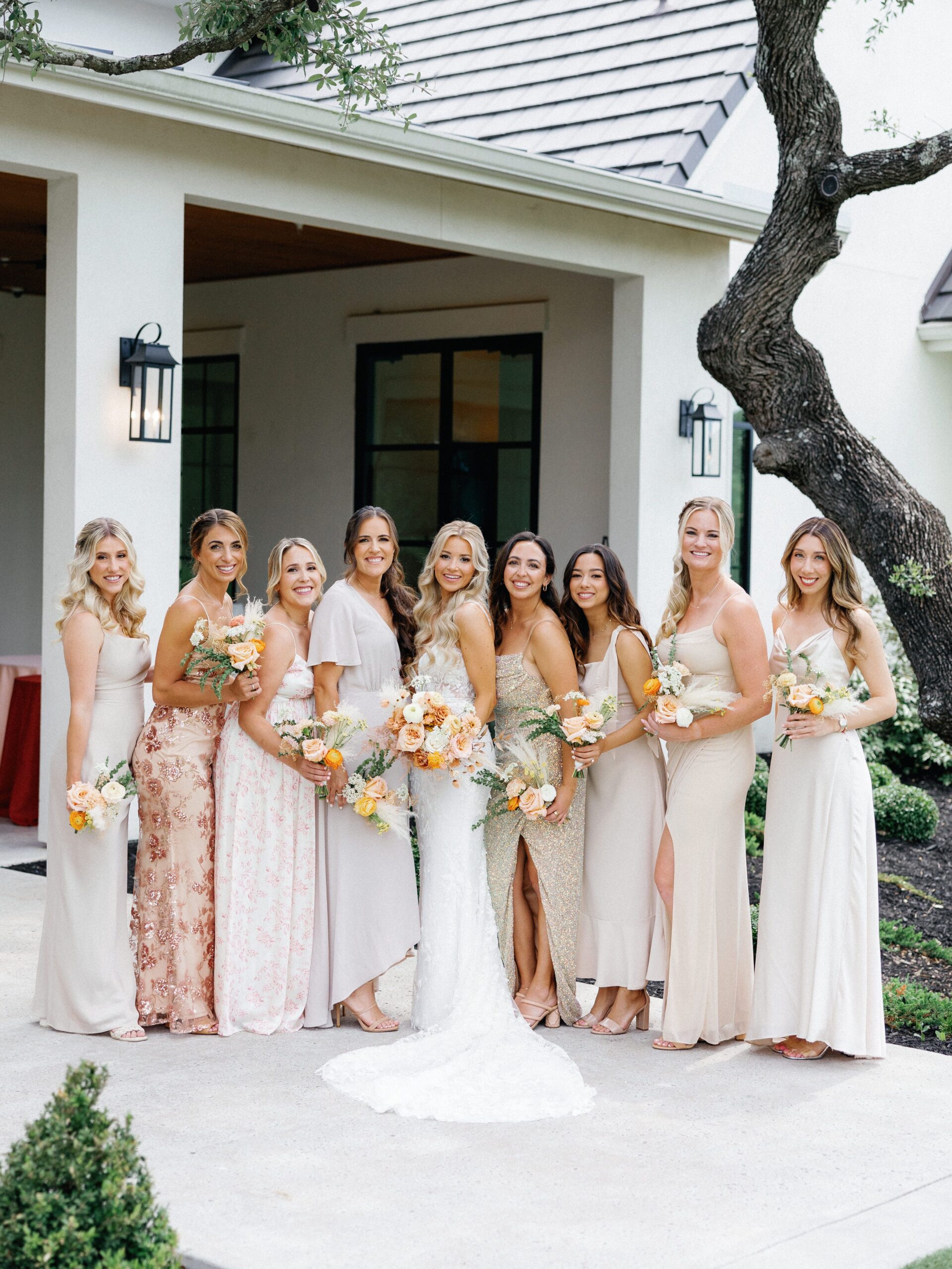 Bride with bridesmaids in neutral mismatched bridesmaid dresses