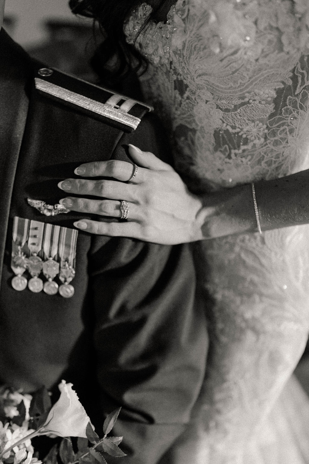 Brides hand resting above Air Force groom's uniform medals