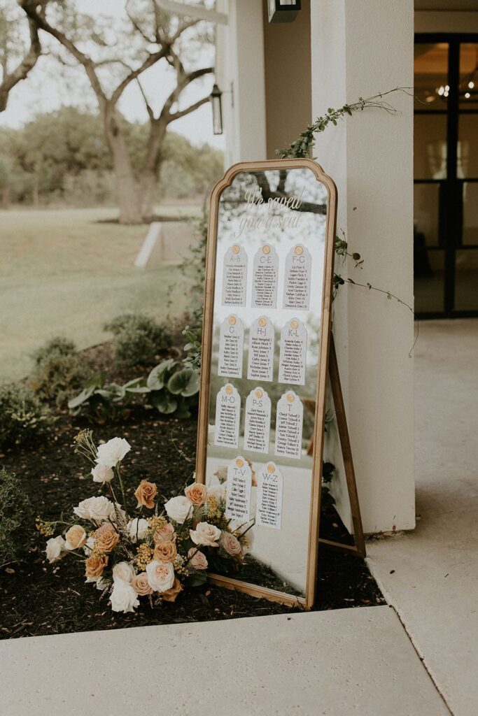 mirror seating chart with floral arrangement