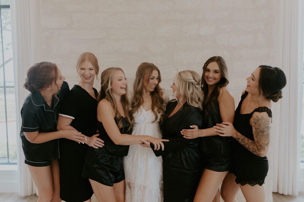 bride and bridesmaids hugging in the bridal suite
