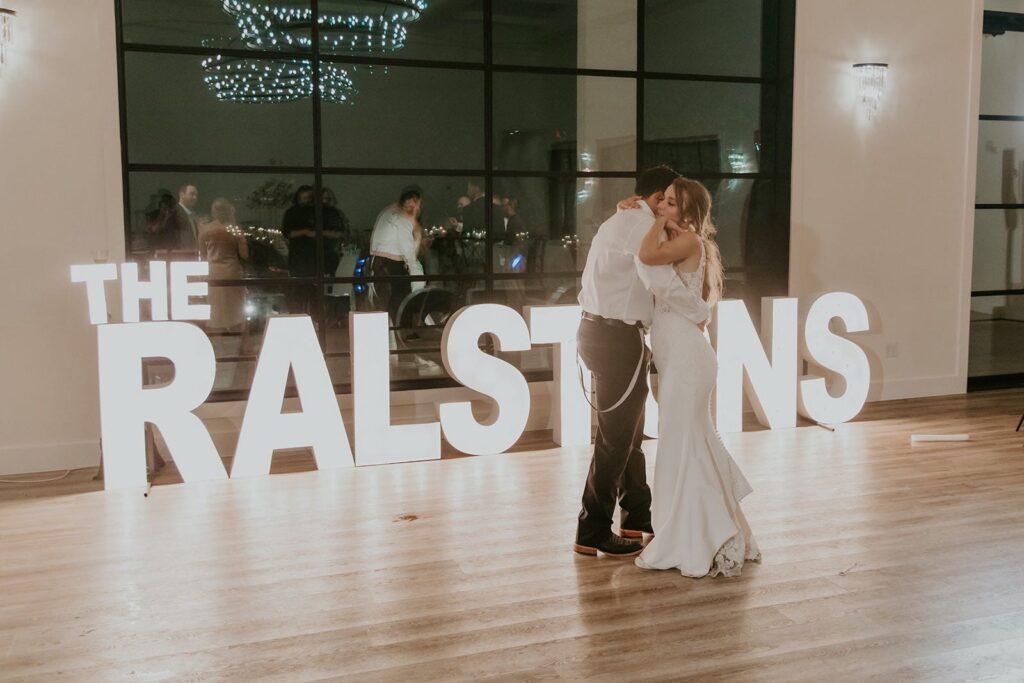 bride and groom private last dance in front of marquee letters