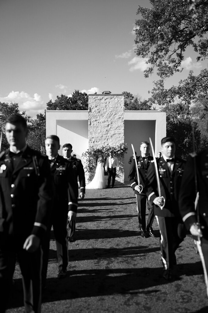Groomsmen prepare for army saber arch at military wedding