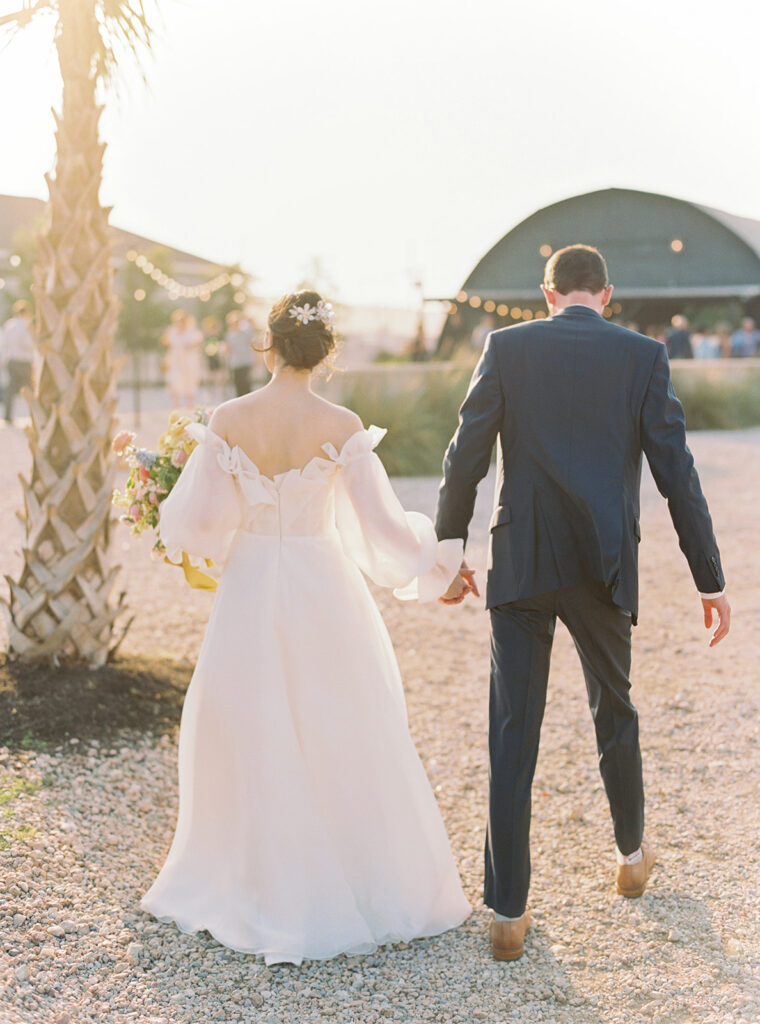 bride and groom walking into the sunset during wedding cocktail hour
