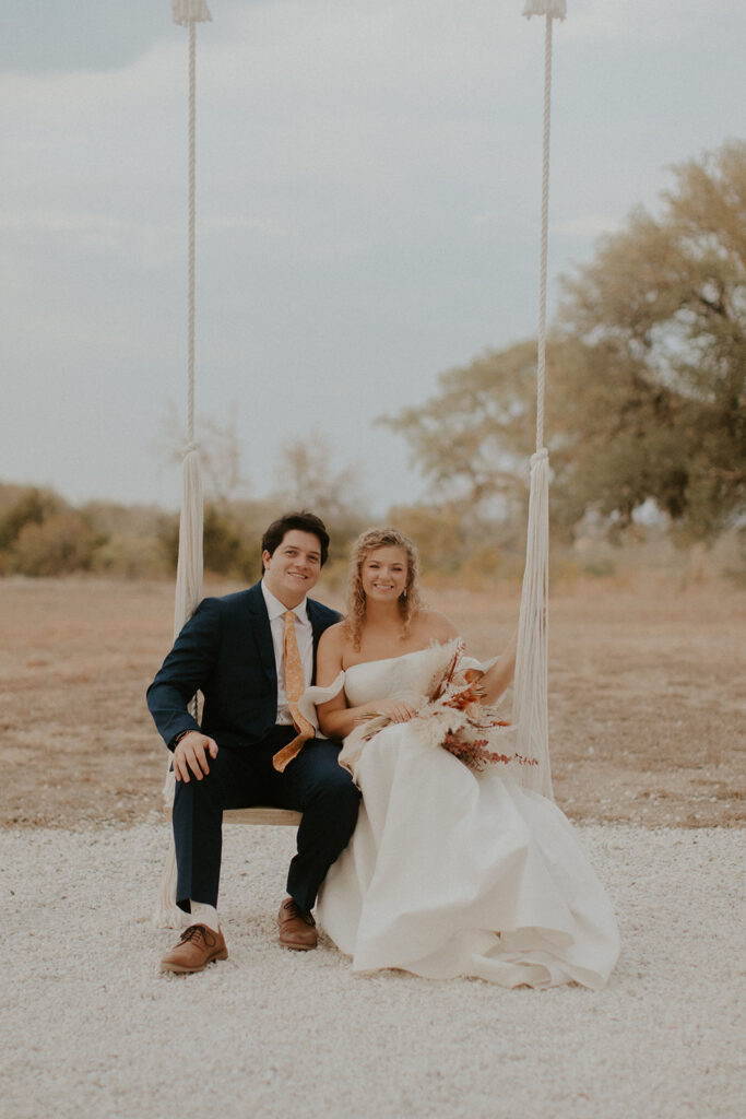 Warm toned photo of bride and groom on swing