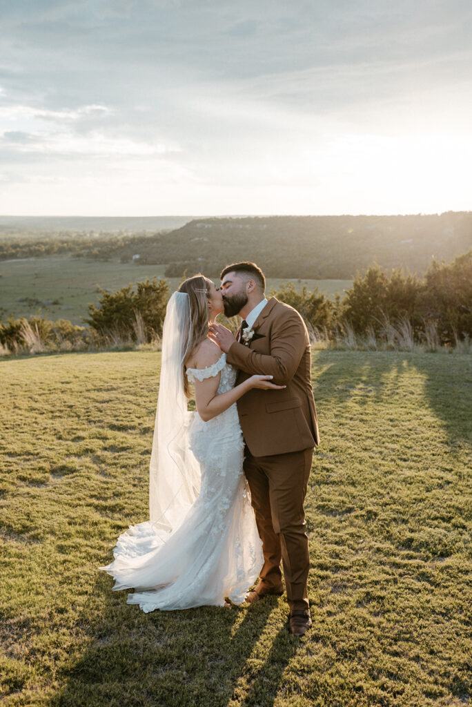 Bride and groom kissing in the sunset in Fredericksburg Texas