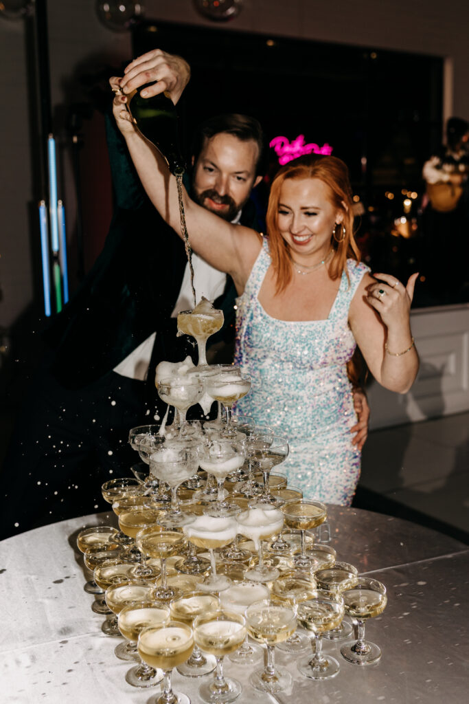 Bride pouring champagne into champagne tower