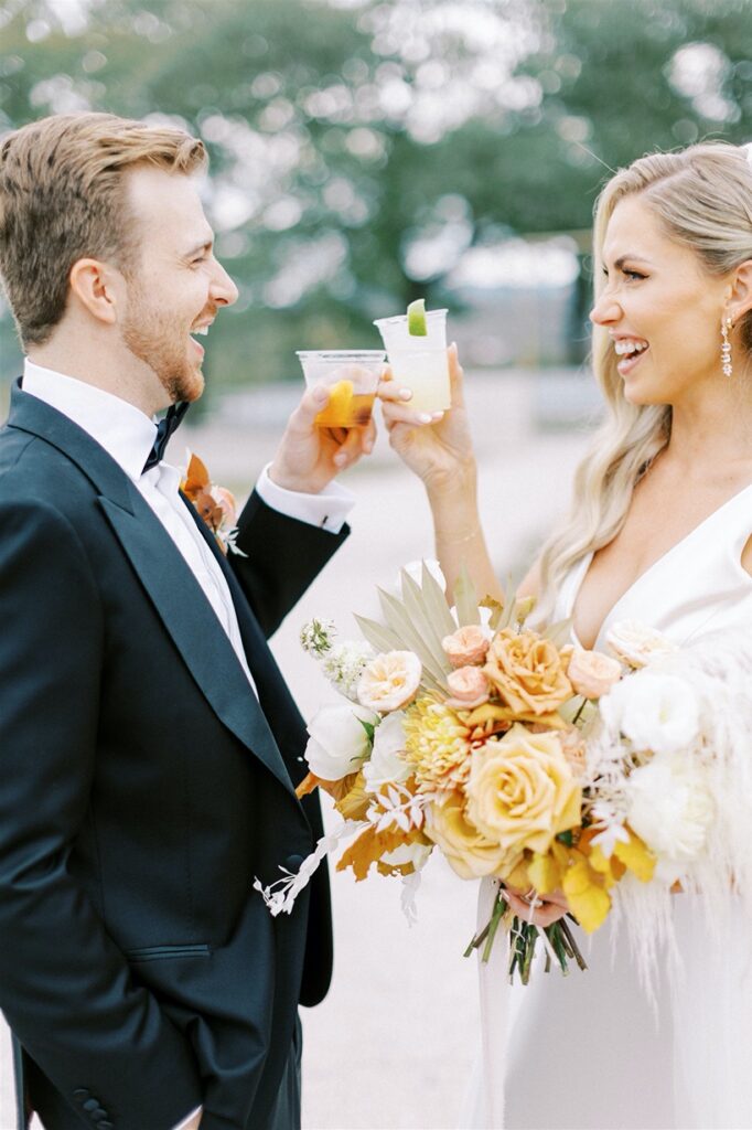couple cheers with drinks at wedding