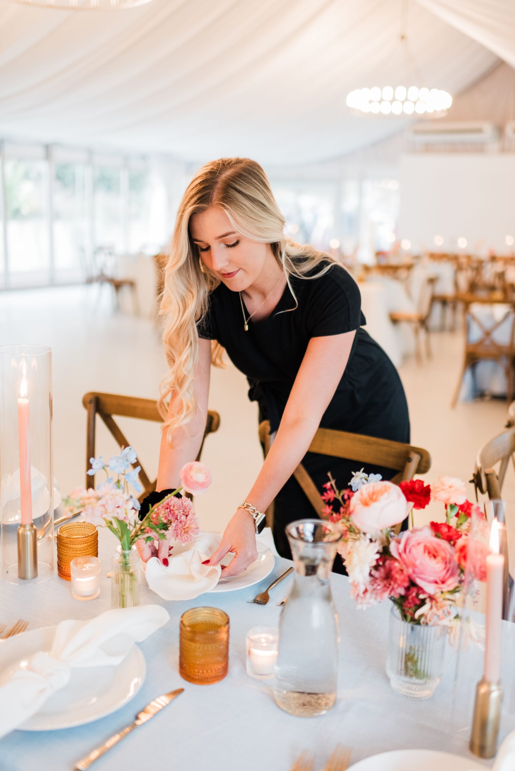 Wedding planner adjusting place setting at a wedding