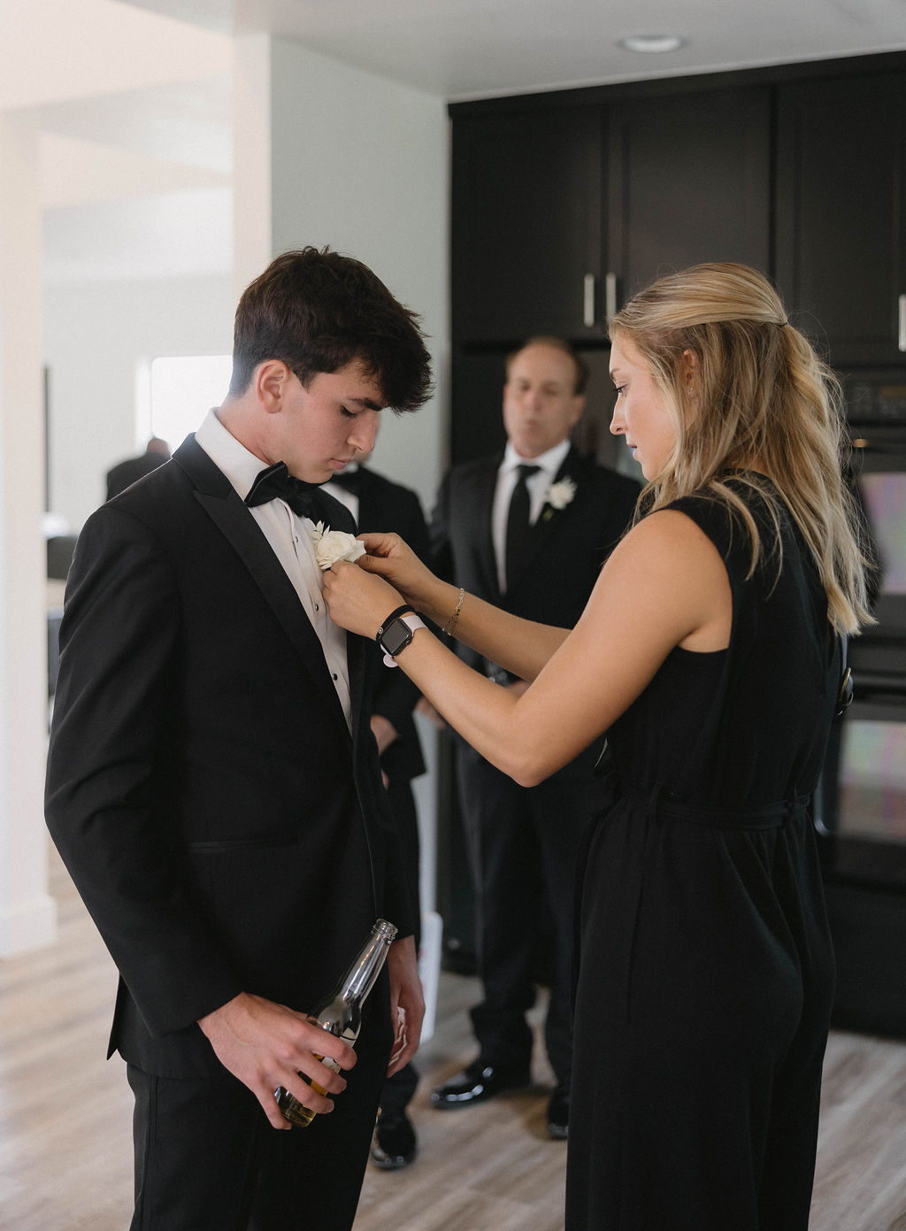 Wedding planner pinning boutonniere onto a groomsmen