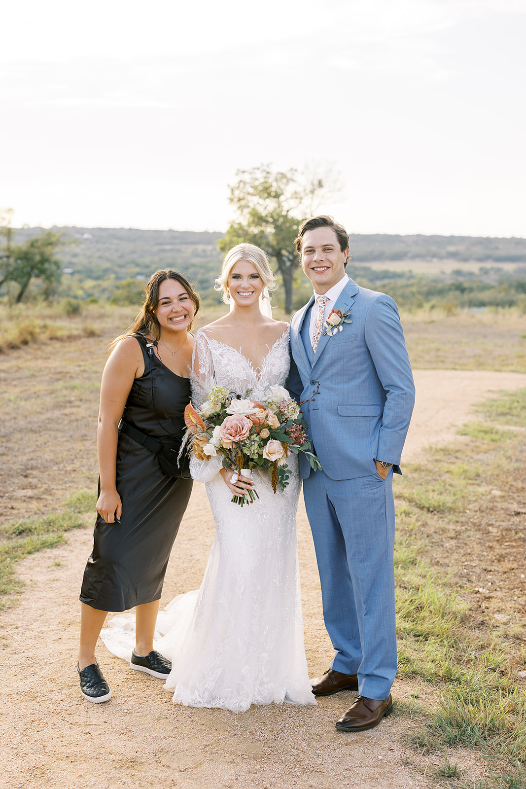 Wedding planner smiling with bride and groom