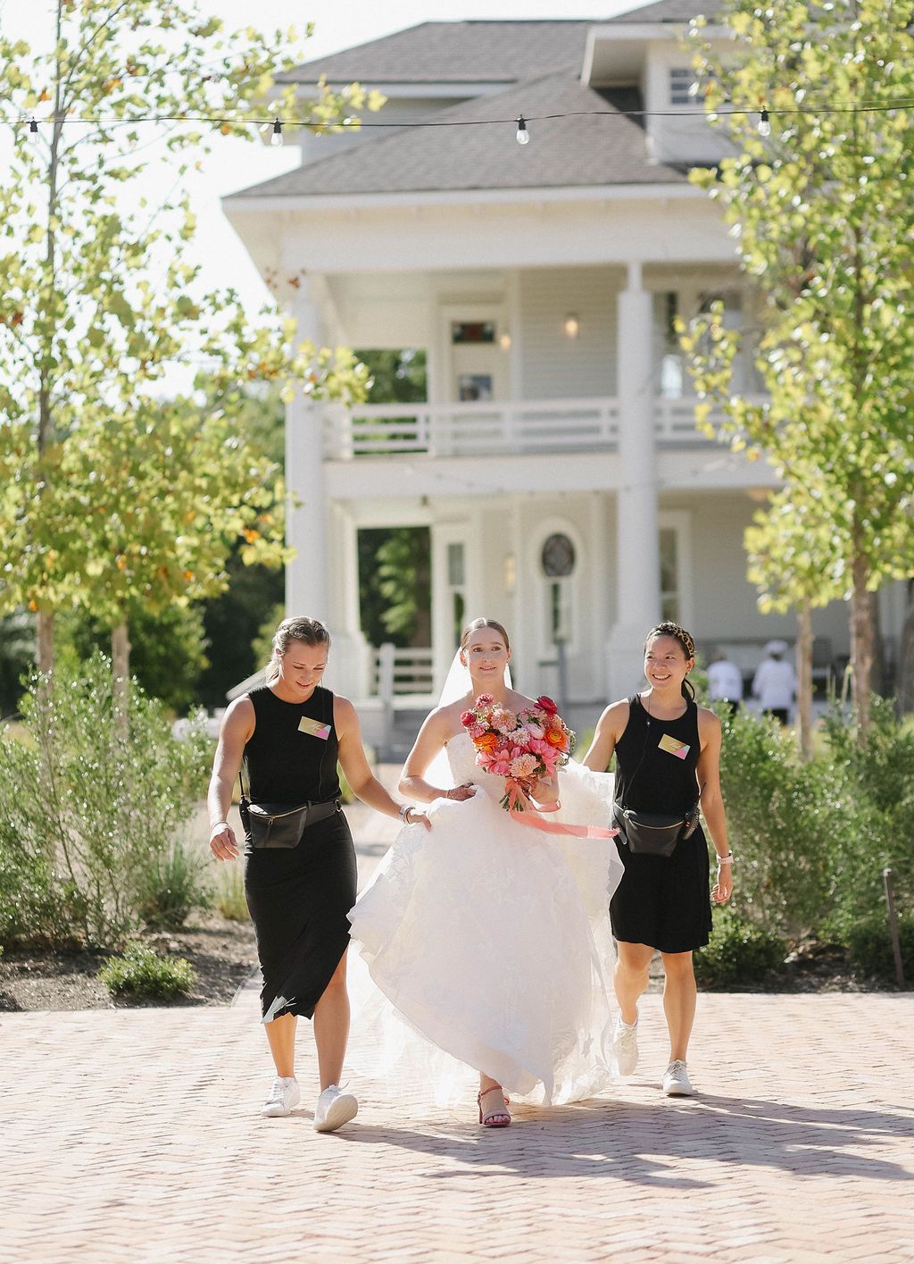 Austin wedding planners carrying bride's dress at The Grand Lady