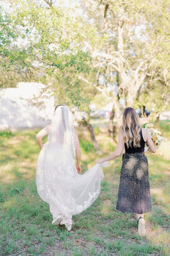 Austin wedding planner carrying bride's dress and bouquet