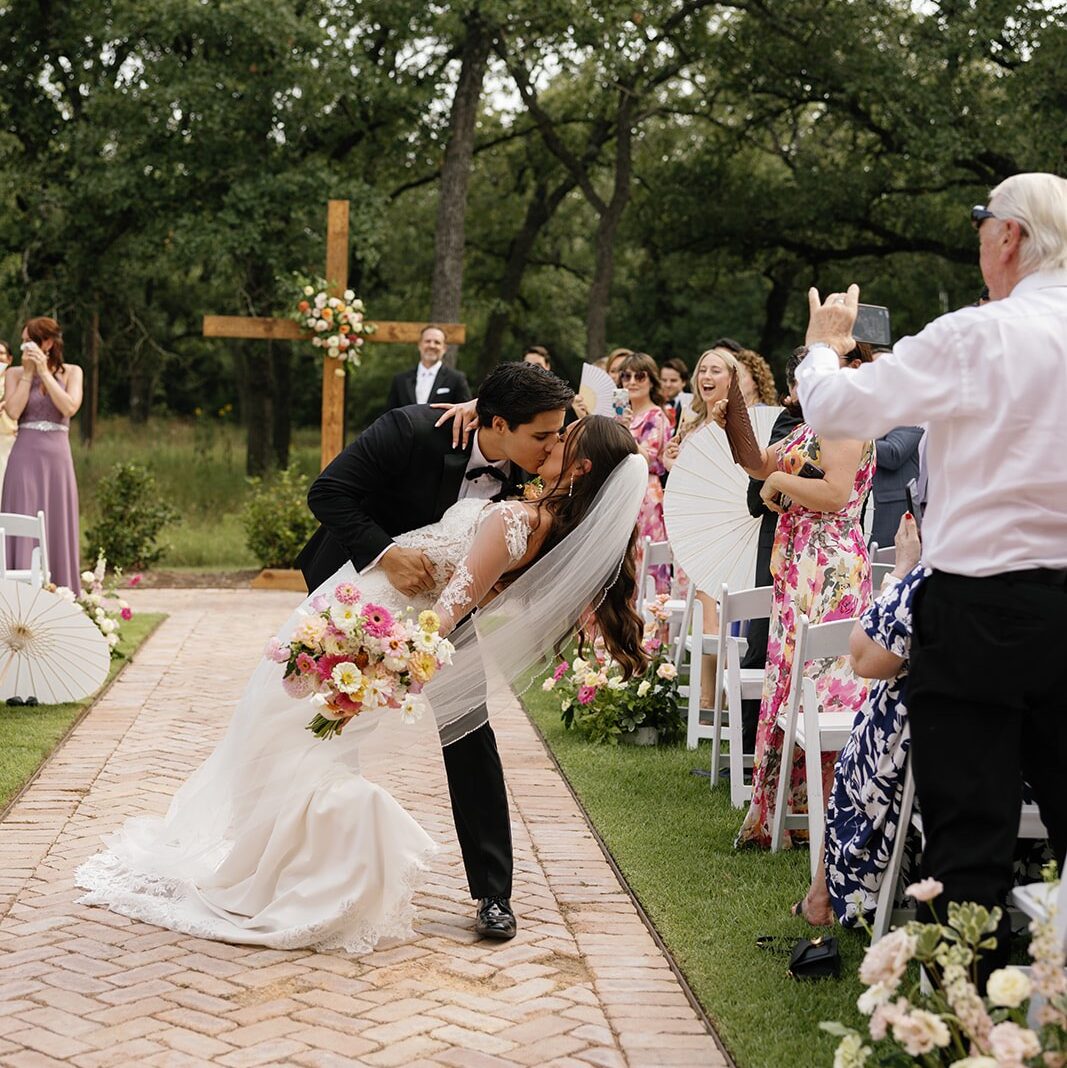 Bride and groom kiss during aisle recessional