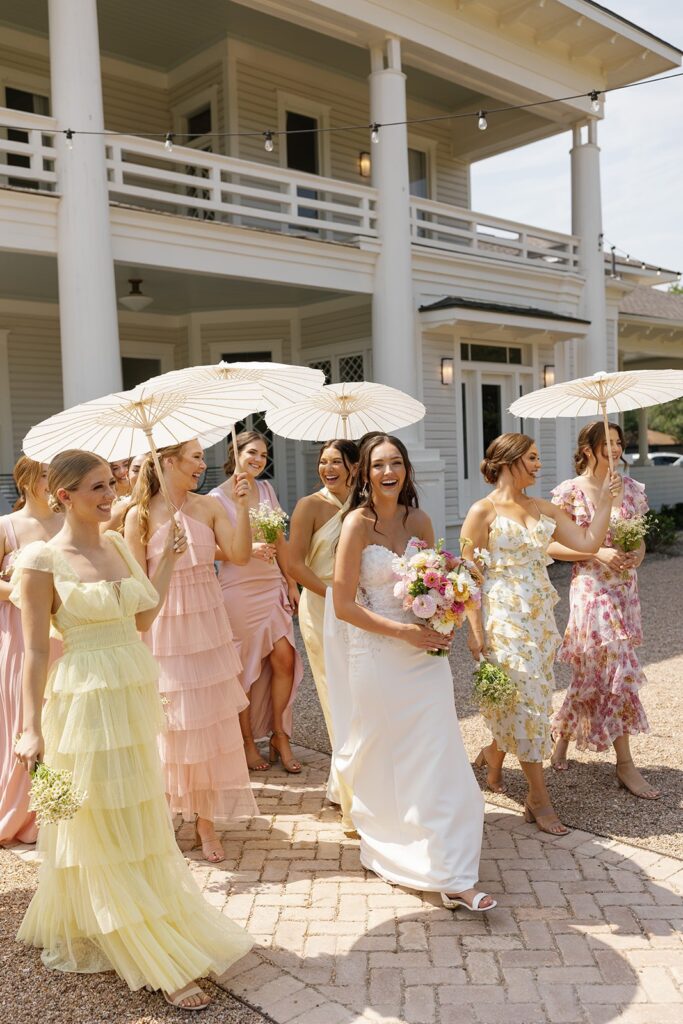 Pink and yellow bridesmaid dresses inspiration at pastel garden wedding with parasols