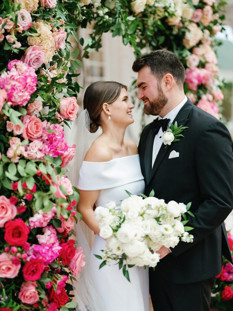 Newlyweds with ombre pink wedding arch