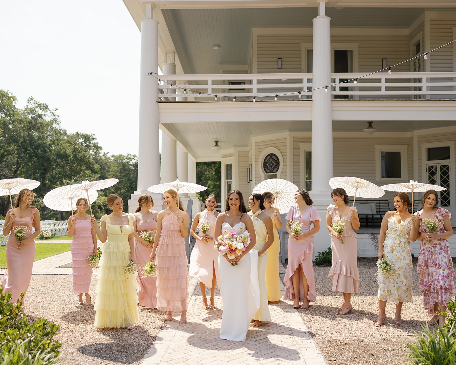 Bride and bridesmaids in mismatched pink and yellow dresses