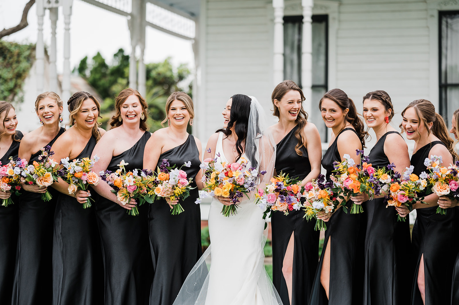 Bride with bridesmaids holding colorful bouquets