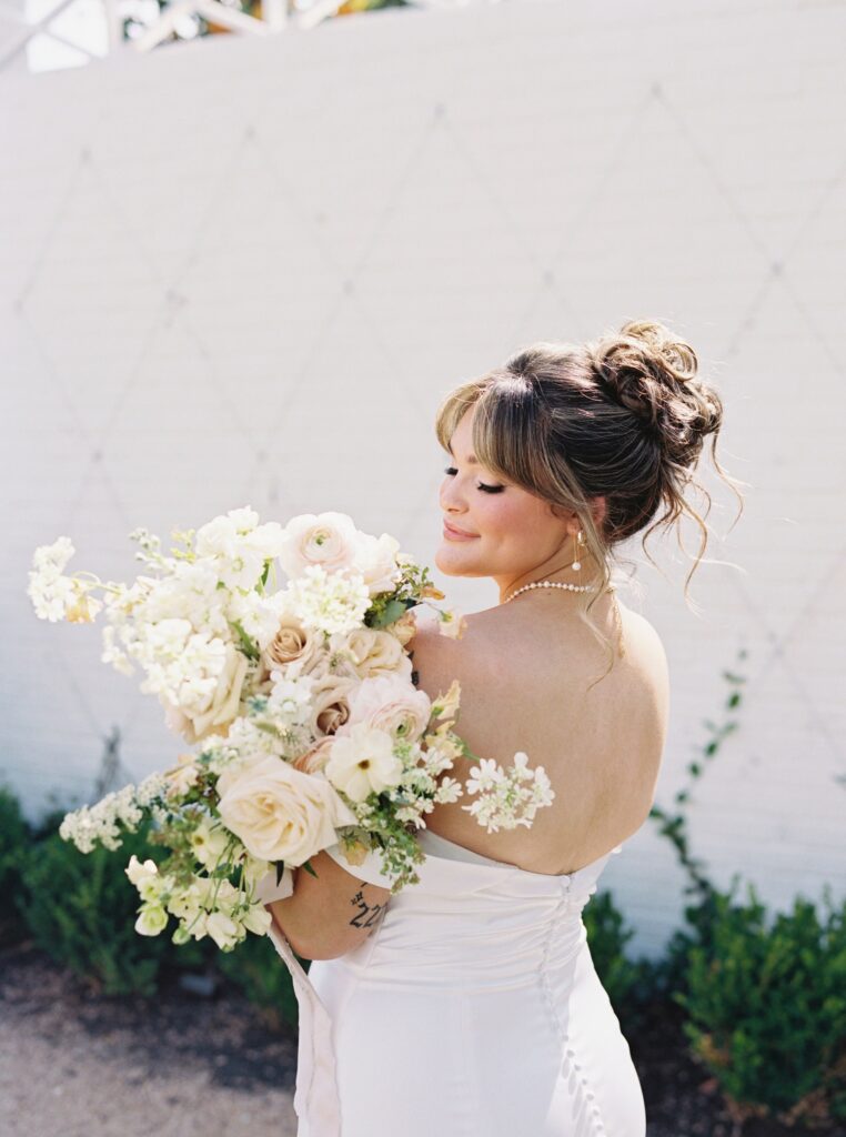 Bride posing with her dreamy wedding bouquet