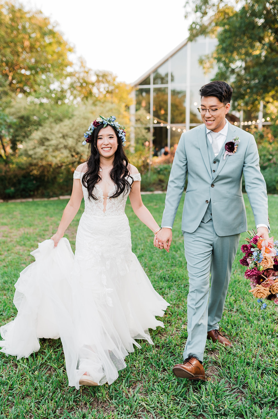 Bride walking with groom and wearing colorful flower crown