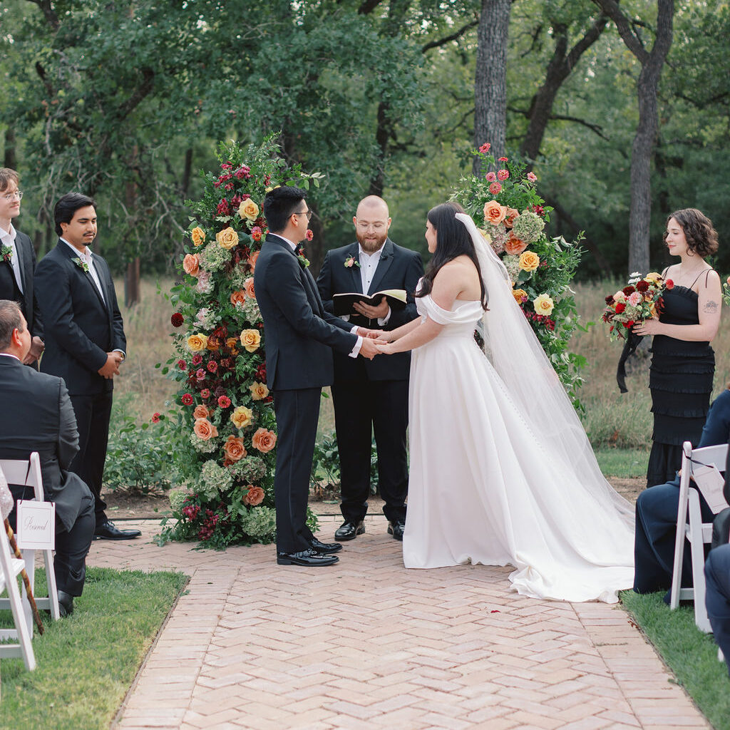 Bride and groom holding hands during their colorful fall wedding ceremony at The Grand Lady