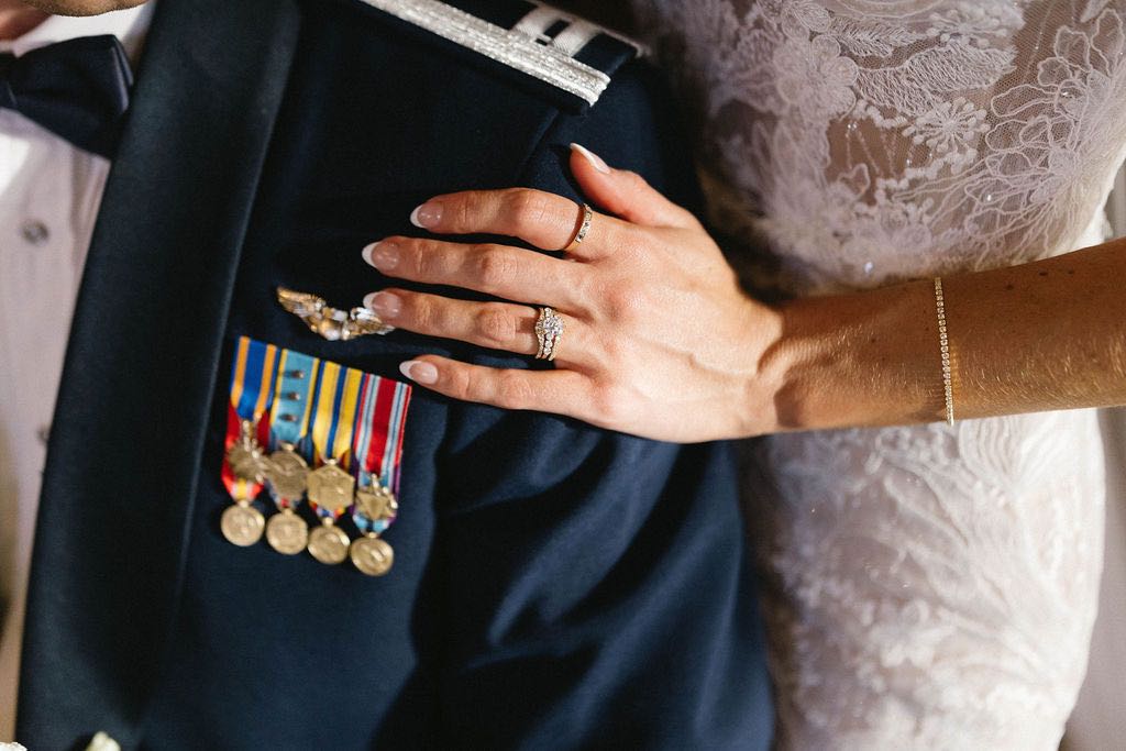 bride's wedding ring next to air force groom's ribbons