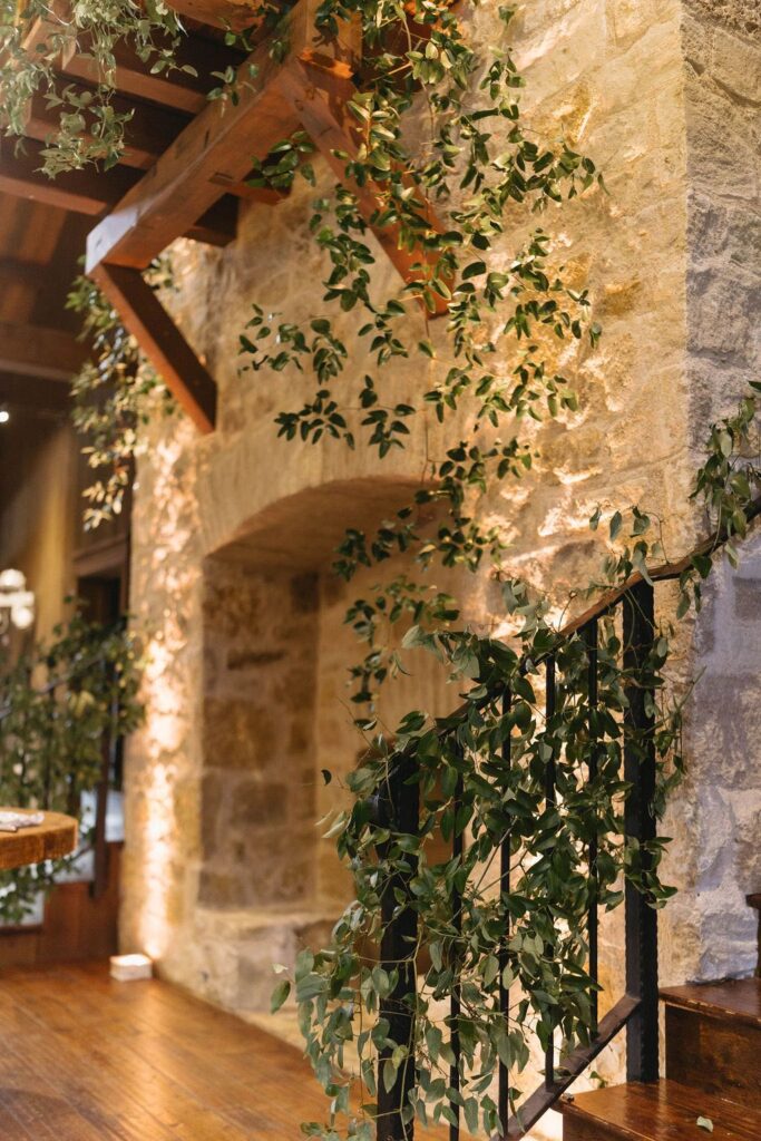 Greenery added to fireplace and stairs at hidden river ranch wedding venue