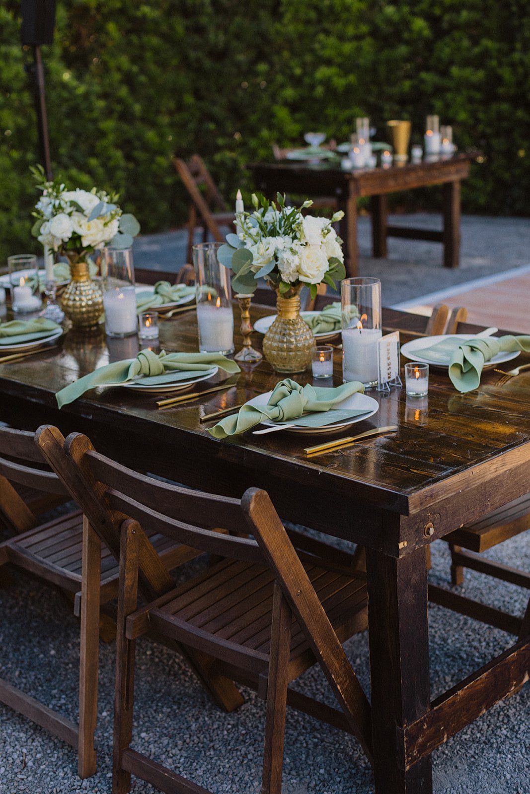 wooden vineyard table with white flowers and sage green napkins