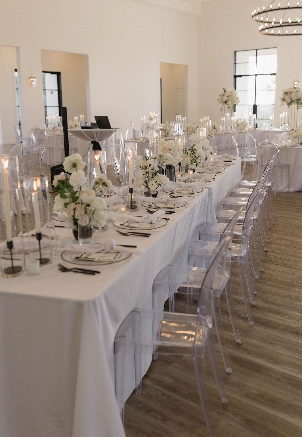 Modern black and white wedding reception decor with acrylic ghost chairs