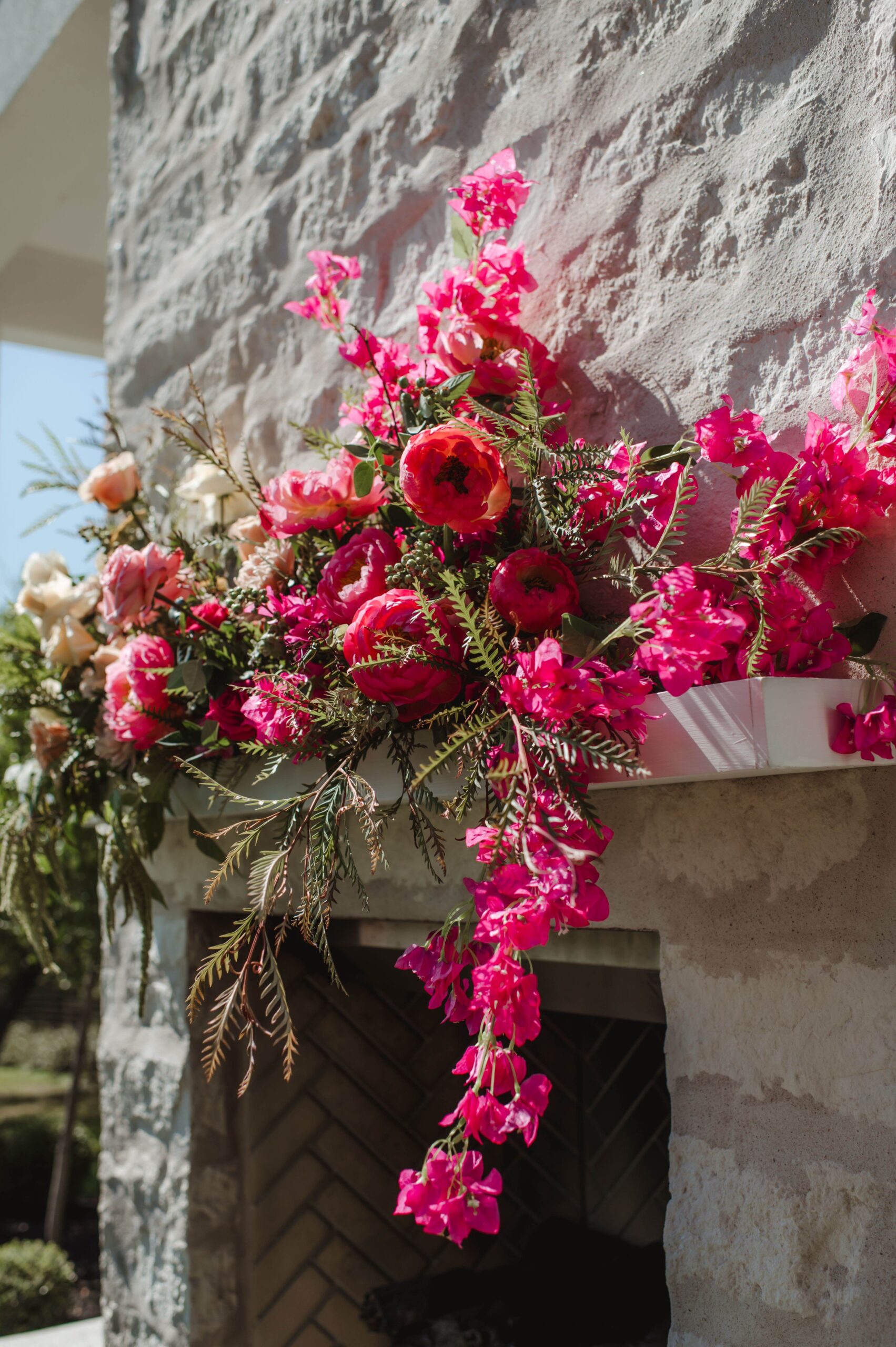 Outdoor summer wedding at The Arlo, featuring bright pink bougainvillea on the fireplace and cactus 