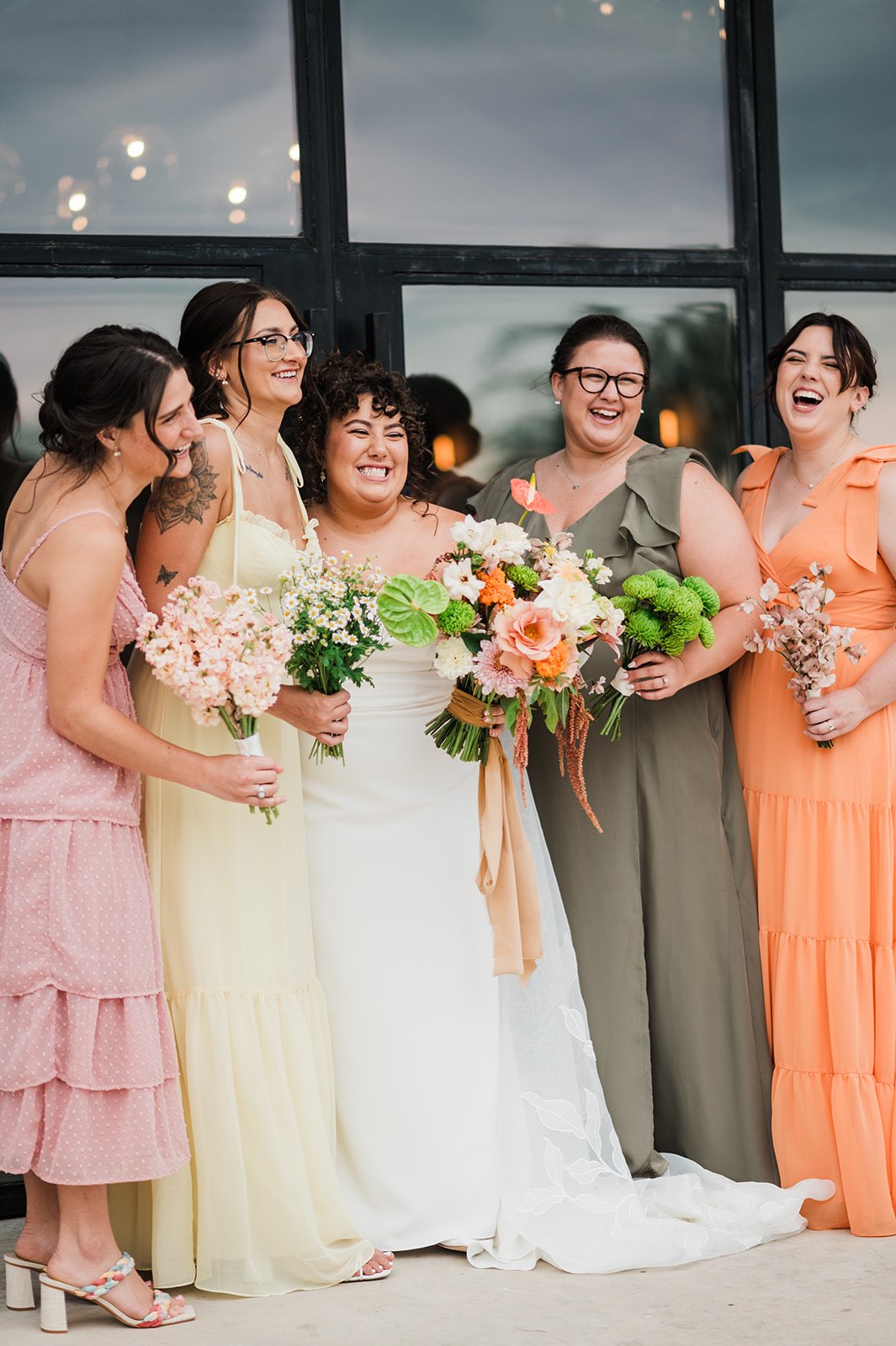 Mismatched pink, peach, yellow and green bridesmaid dresses