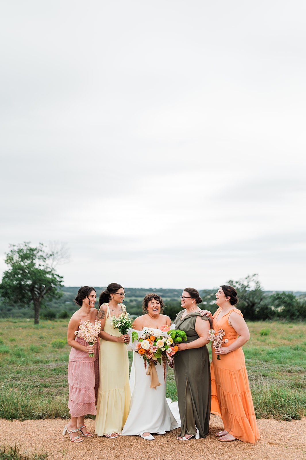 Mismatched pink, peach, yellow and green bridesmaid dresses