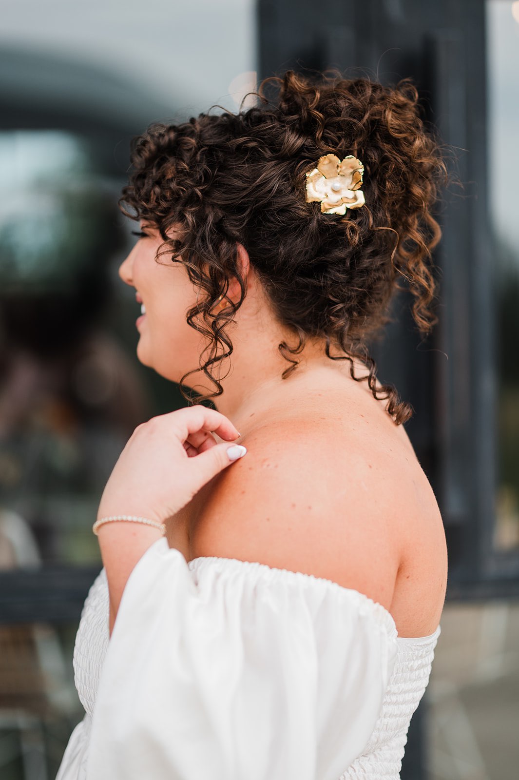 Bridal updo with natural curls and vintage wedding pin