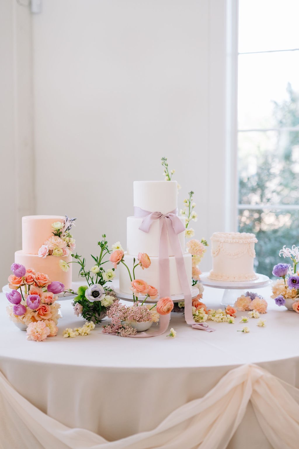 Colorful spring wedding cake display with three custom cakes