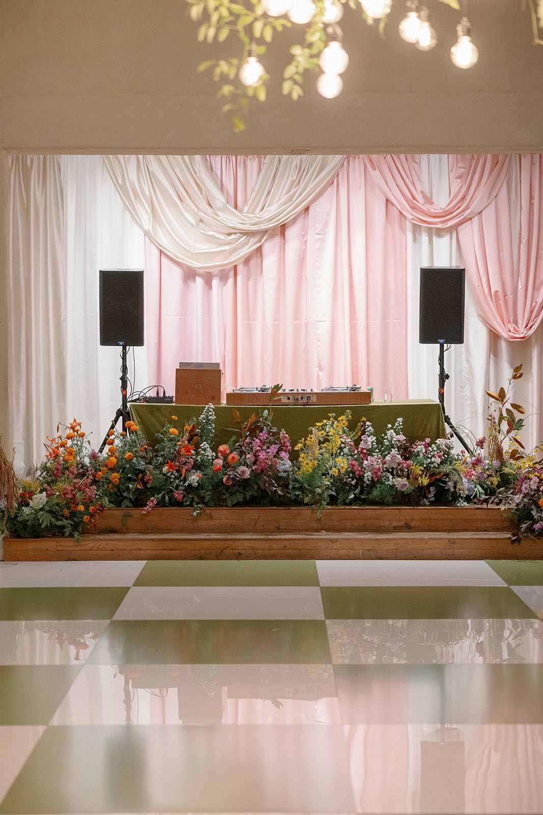 funky, colorful wedding reception with green and white checkered dance floor and stage draping